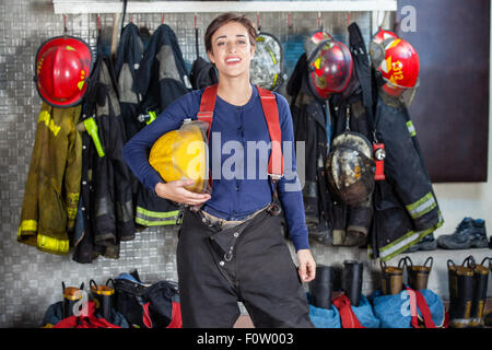 Fiducioso donna pompiere in piedi presso la stazione dei vigili del fuoco Foto Stock