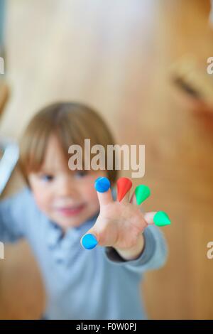 Stretta di mano ragazzi con luminosi coni colorati su dita Foto Stock