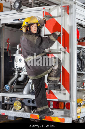 Arrampicata firewoman carrello alla stazione dei vigili del fuoco Foto Stock