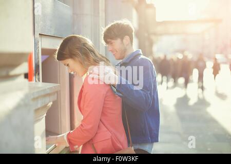 Paio di prelevare denaro dal bancomat su Street, Londra, Regno Unito Foto Stock