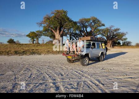 Coppia con figli sul veicolo, Nxai Pan National Park, Deserto Kalahari, Africa Foto Stock