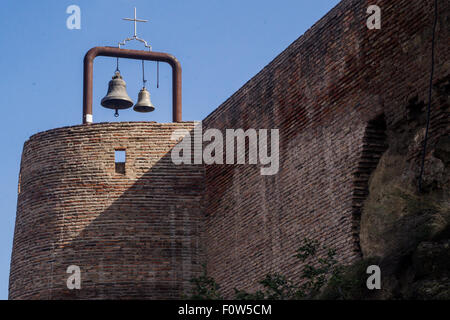 Storica torre in mattoni con due campane sotto un cielo azzurro limpido in una posizione tranquilla Foto Stock