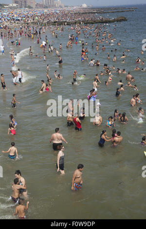 Migliaia di persone per godersi la spiaggia e acqua lungo l'Oceano Atlantico a Coney Island, Brooklyn, New York. Foto Stock