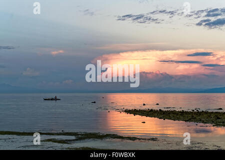 Un pescatore di ritorno da un viaggio di pesca. Come il sole del mattino viene gradualmente fino, barche da pesca stanno tornando con le loro catture Foto Stock