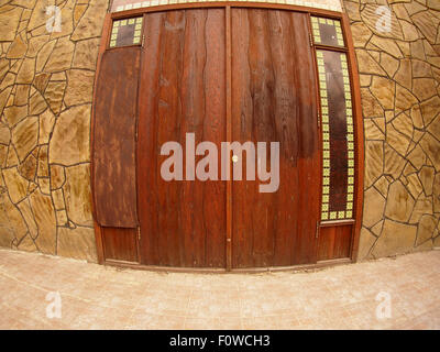 Porta di legno in un muro di pietra con ampio angolo lente fisheye view Foto Stock