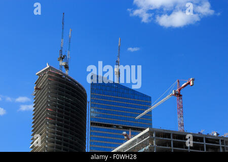 Più gru lavorando su un grande sito di costruzione. Foto Stock