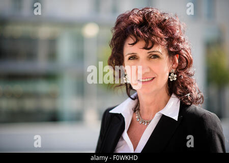 Ritratto di sorridere senior business woman in una strada moderna Foto Stock