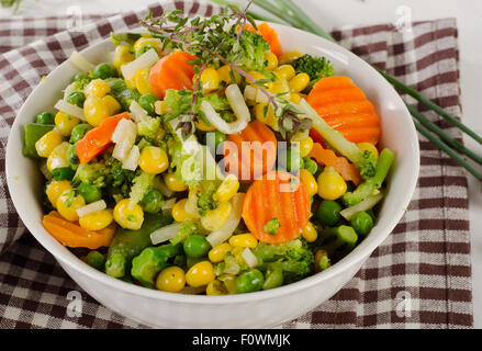 Verdure miste con erbe fresche in una ciotola bianco. Messa a fuoco selettiva Foto Stock