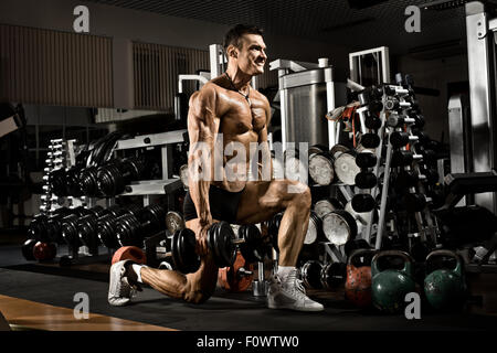 Molto potere athletic guy , eseguire esercizi con i pesi in palestra Foto Stock