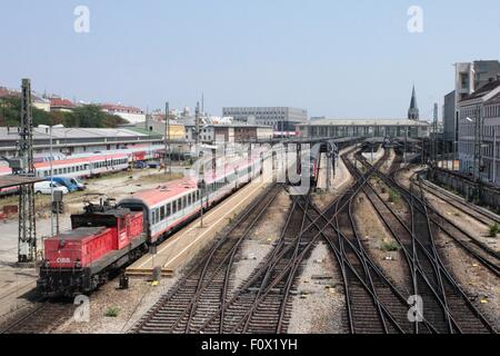 Linea ferroviaria con treni all'ingresso alla stazione ferroviaria Westbahnhof, Vienna, Austria con electric loco shuntando i pullman. Foto Stock