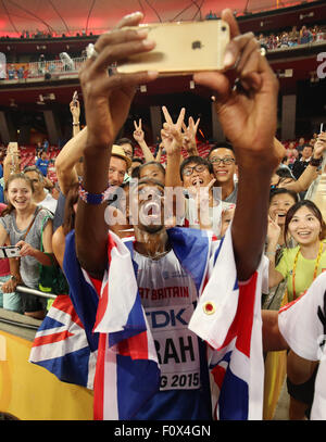 Pechino, Cina. Il 22 agosto, 2015. La Gran Bretagna è Mohamed Farah festeggia con gli spettatori e prende le immagini dopo aver vinto il uomini 10.000 M finale al XV Associazione Internazionale delle Federazioni di Atletica (IAAF) Atletica Campionati del mondo presso il National Stadium, noto come Bird's Nest, a Pechino, in Cina, il 22 agosto 2015. Foto: Christian Charisius/dpa/Alamy Live News Foto Stock