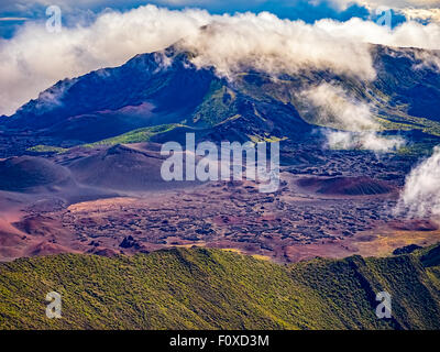 Spettacolare Cratere Haleakala dall'aria con le nuvole passando sopra il cerchio. Foto Stock