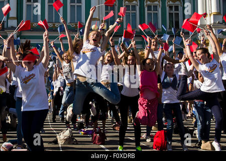 San Pietroburgo, Russia. Il 22 agosto, 2015. La bandiera nazionale di giorno è stato celebrato a San Pietroburgo il 22 agosto 2015. Diverse centinaia di giovani con piccoli rossi, blu e bandiere bianche performeed una danza sulla piazza del palazzo nella parte anteriore del Museo Hermitage. In Russia la bandiera attuale è stata introdotta dal Presidente Boris Eltsin al posto della vecchia bandiera sovietica e rimane uno dei pochi simboli della nuova Russia democratica che esiste fino ad oggi. Credito: studio204/Alamy Live News Foto Stock