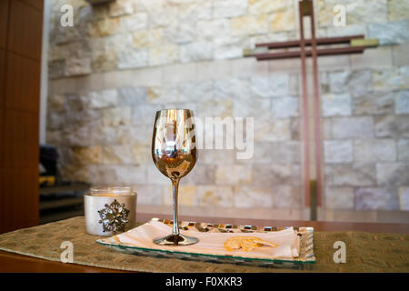 Bicchiere di vino di comunione e di pane in chiesa cristiana con la croce. Foto Stock
