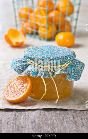 Tangerine inceppamento in un vasetto di vetro, tangerini su un sfondo di lino Foto Stock