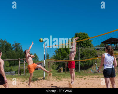 Un gruppo di ragazzi giocare pallavolo in spiaggia Foto Stock