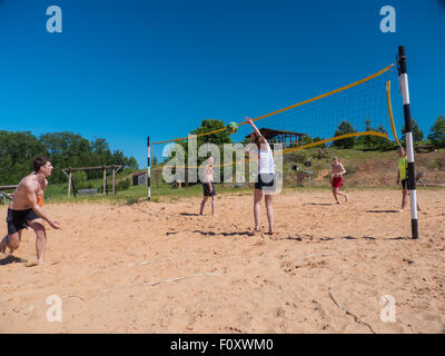 Un gruppo di ragazzi giocare pallavolo in spiaggia Foto Stock