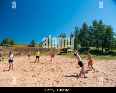 Un gruppo di ragazzi giocare pallavolo in spiaggia Foto Stock