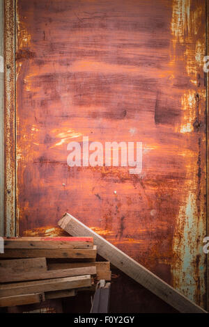 Legname posto nella parte anteriore di una pila di vecchi porta in ferro. Foto Stock