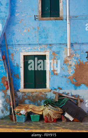 Attrezzatura da pesca impilate contro il peeling blu decadendo muro di una casa Burano Laguna di Venezia Veneto Italia Europa Foto Stock