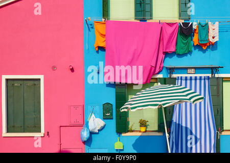 Colorate case dipinte con ombrellone e lavaggio appendere fuori Burano Laguna di Venezia Veneto Italia Europa Foto Stock