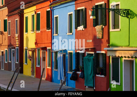 Fila di vivacemente case dipinte a sunrise Burano Laguna di Venezia Veneto Italia Europa Foto Stock