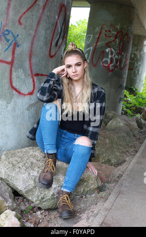 Robusto moody ragazza adolescente in una posizione urbana indossando un setto nel suo naso. Foto Stock