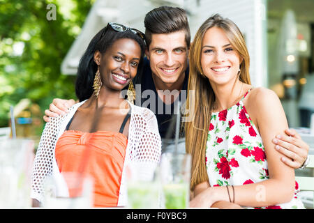 Felice giovani amici sorridere all'esterno essendo vicini gli uni agli altri in un giorno di estate Foto Stock