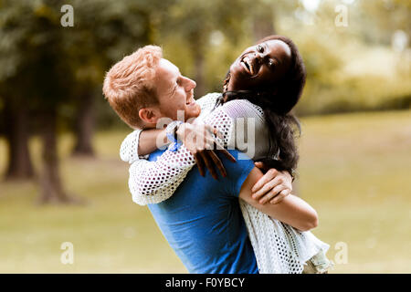 Ritratto di una felice coppia danzante e abbracciando in un parco all'aperto Foto Stock