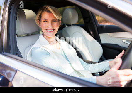 Felice donna di mezza età alla guida di una macchina Foto Stock