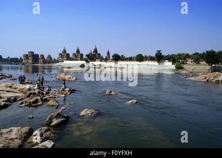 Bagnanti a testa in giù per il fiume Betwa nel villaggio di Orchha, Madhya Pradesh, India del Nord Foto Stock