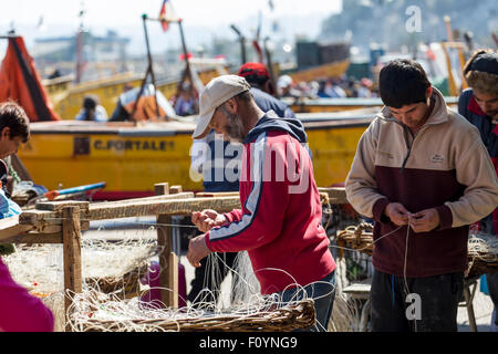 I pescatori riparare reti a Caleta Portales, Valparaiso, Cile Foto Stock