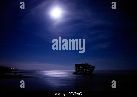 Il naufragio di Peter Iredale rimane accentuato dalla luce della Luna nella notte di nebbia sulla costa del Pacifico Foto Stock