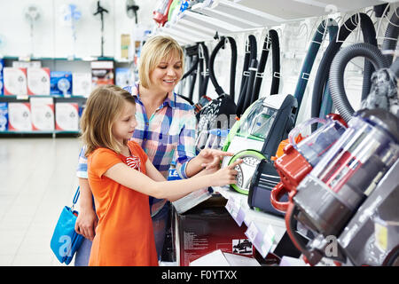 Madre e figlia shopping per aspiratore elettrico, sorridente Foto Stock