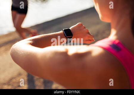 Close up shpt di sportive guardando il suo cronometro. Controllo del pareggiatore ora sul suo smartwatch. Foto Stock