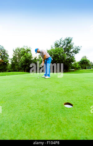 Il Golfer pronto a prendere il colpo sul putting green Foto Stock