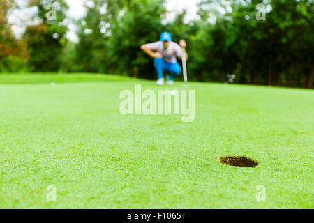 Il Golfer pronto a prendere il colpo sul putting green Foto Stock