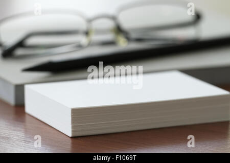 Close up di Blank business cards con matita e bicchieri su office tavolo in legno Foto Stock