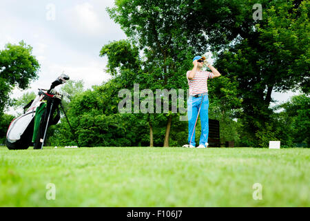 Il Golfer ottenere pronto a colpire il primo colpo lungo Foto Stock