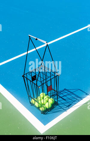 Bellissimo campo da tennis con una palla canestro e palle da tennis in esso Foto Stock
