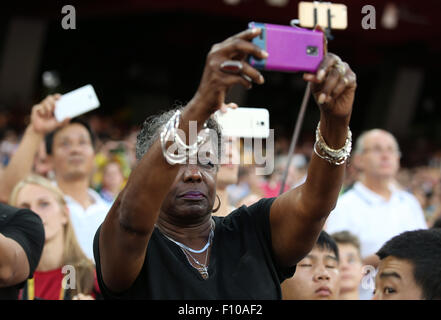 Pechino, Cina. 24 Ago, 2015. Jeanette, madre della medaglia di argento Justin Gatlin degli STATI UNITI D'AMERICA, prende una foto con il suo telefono cellulare durante la premiazione per gli uomini 100m final durante la XV Associazione Internazionale delle Federazioni di Atletica (IAAF) Atletica Campionati del Mondo a Pechino in Cina, 24 agosto 2015. © dpa picture alliance/Alamy Live News © dpa picture alliance/Alamy Live News Credito: dpa picture alliance/Alamy Live News Foto Stock