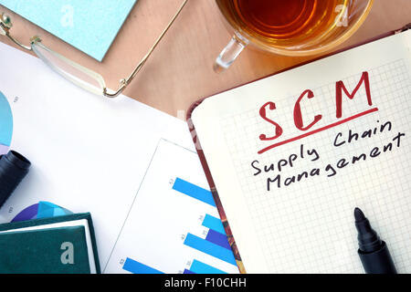 Blocco note con word SCM supply chain management e il concetto di marcatore. Foto Stock