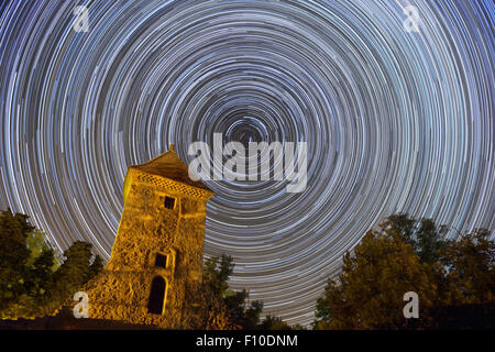 Stelle lungo sentieri intorno a north star più antica torre del castello di evidenziazione di primo piano di rotazione della terra Foto Stock