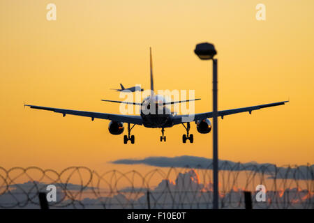 Un British Airways Airbus A319 terre su Heathrow Airport la pista 27R come nella distanza di un British Airways A380 si discosta dalla runw Foto Stock