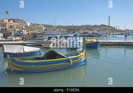 Colorato dipinto luminosamente tradizionali barche da pesca nel porto, il villaggio di pescatori di Marsaxlokk, malta. Foto Stock