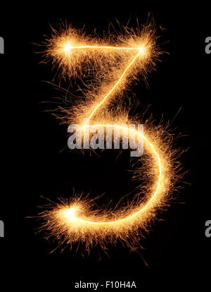 '3' numero estratto con brillantini bengali isolati su sfondo nero Foto Stock