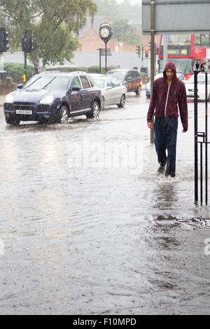 Purley, Londra, UK, 24 agosto 2015. Un pedone sloshes attraverso in piedi acqua di inondazione in Purley. Un giallo allarme alluvione per Londra è stato rilasciato dal Met Office. Una quindicina di giorni di pioggia è previsto a cadere in 24 ore. Credito: Dave Stevenson/Alamy Live News Foto Stock