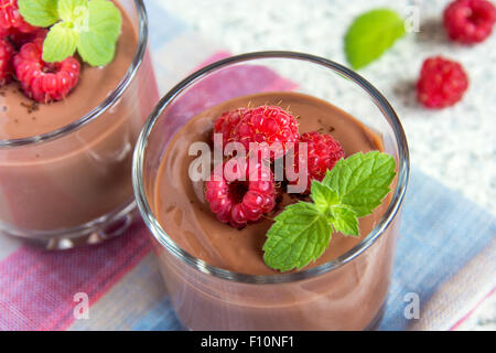 Mousse al cioccolato con lampone e menta nella porzione bicchieri Foto Stock