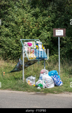 Lo scarico illegale di rifiuti domestici sacchetti in net lungo la banchina destinata per il lancio in lattine e bottiglie di plastica Foto Stock