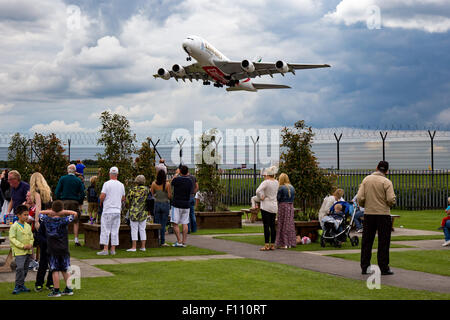 Emirates Airbus A380-800 salite lontano dalla pista 05L all'aeroporto di Manchester, come spettatori guarda su da "L'aeroporto Pub'. Foto Stock